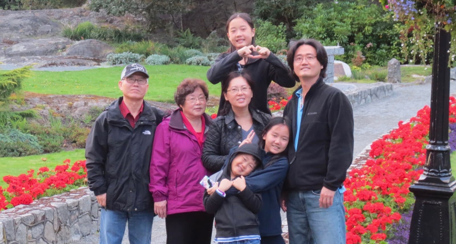 The Lee family, founders of Generations of Hope, standing together in a flower garden